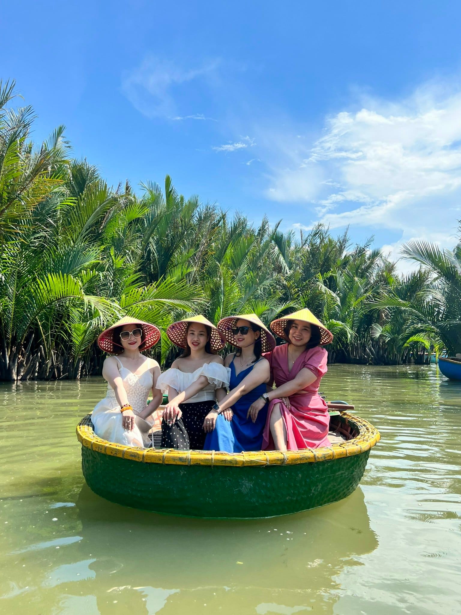 Du khách đội nón lá trên thuyền thúng